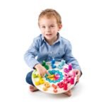 Fëmijë duke përdorur orën Montessori prej druri