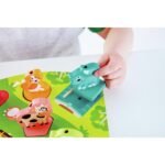 Fëmijë duke vendosur figurën në puzzle druri me tinguj