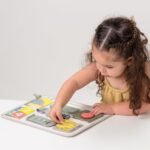 Fëmijë duke luajtur me tabelën e aktiviteteve Taf Toys