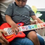 Fëmijë duke luajtur me kitarën interaktive Hape Baby Einstein