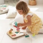 Fëmijë duke vendosur kafshët në puzzle-in prej druri me tinguj