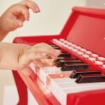 Fëmijë duke luajtur në tastet e pianos elektrike Hape